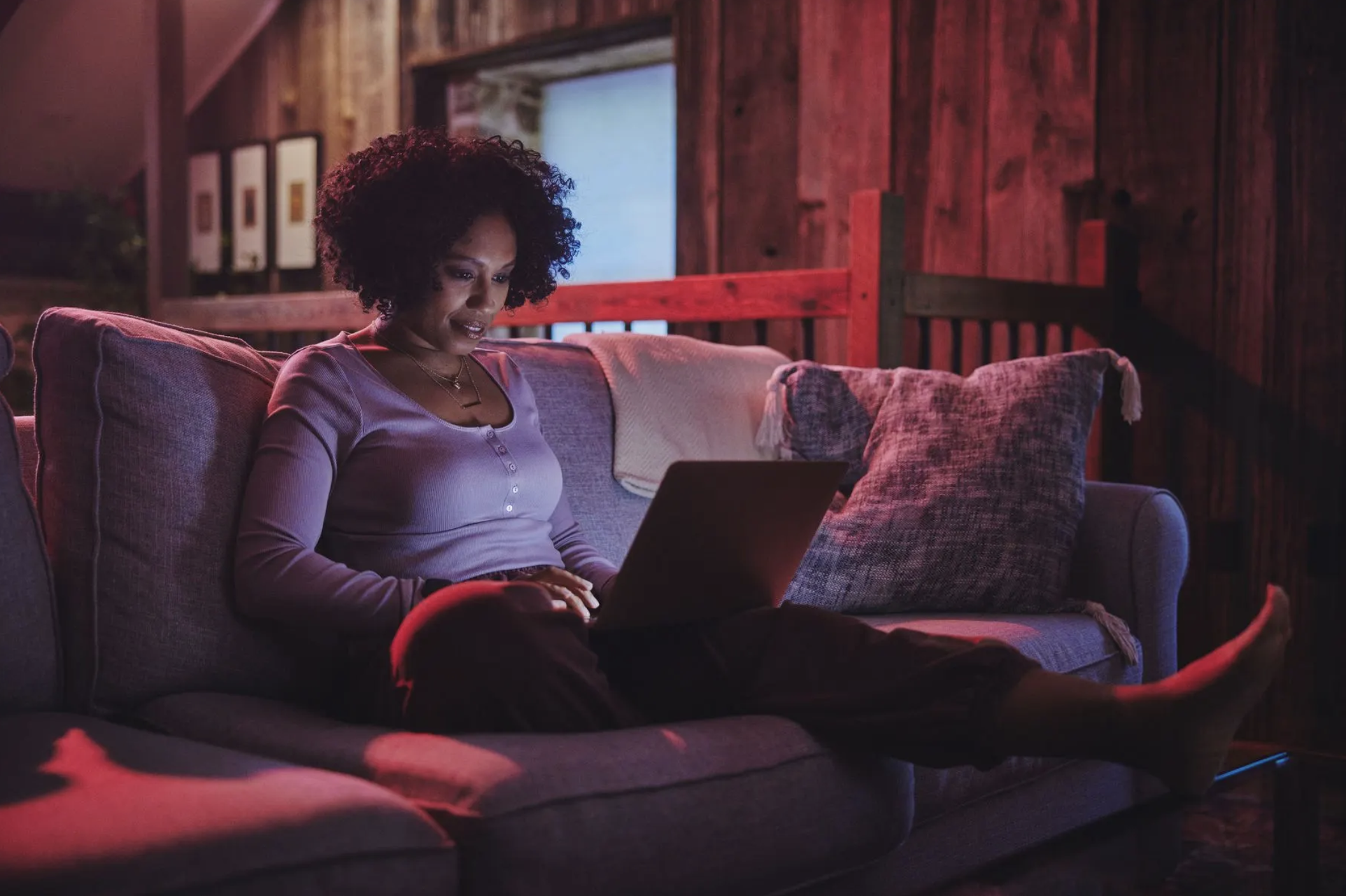 Woman relaxing on a sofa with a laptop